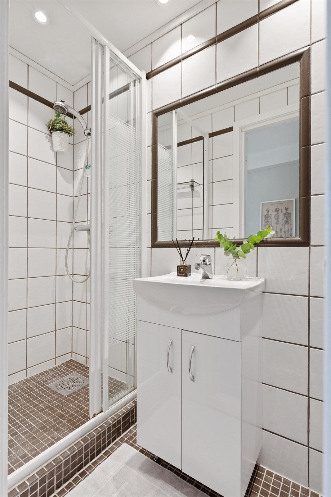 Badet er pent flislagt og har varmekabler i gulvet og downlights i taket. Innredningen består av skapinnredning med heldekkende servant, innmurt speil, dusjhjørne med skyvedør og termostat batteri, servant med skapinnredning, Galleribilde