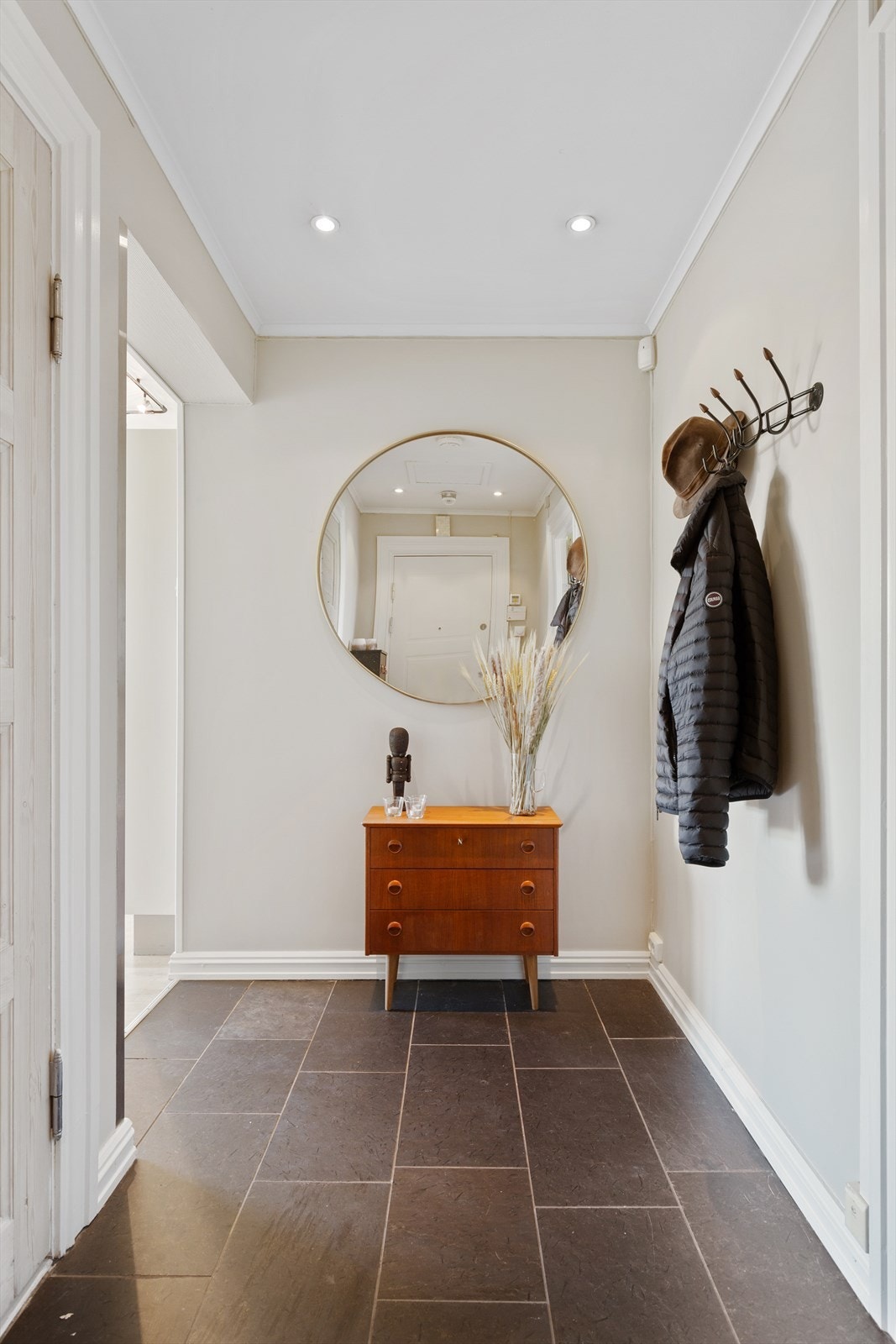 Fra felles trappoppgang ønskes du velkommen inn i en lys og innbydende entré med downlights i taket og flislagte gulv med varmekabler. Galleribilde