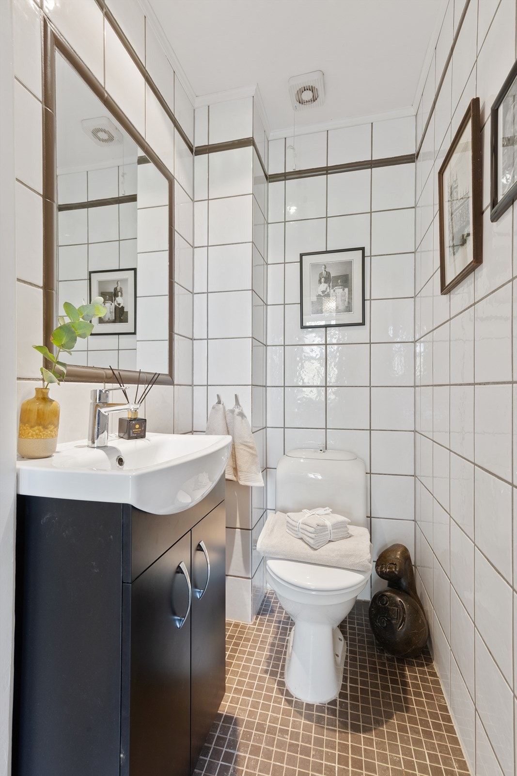 I tilknytningen til entréen er det et praktisk og separat WC med fliser på gulv- og veggflatene. I gulvet er det varmekabler. Innredningen består av toalett, skapinnredning med heldekkende servant og innmurt speil. Galleribilde