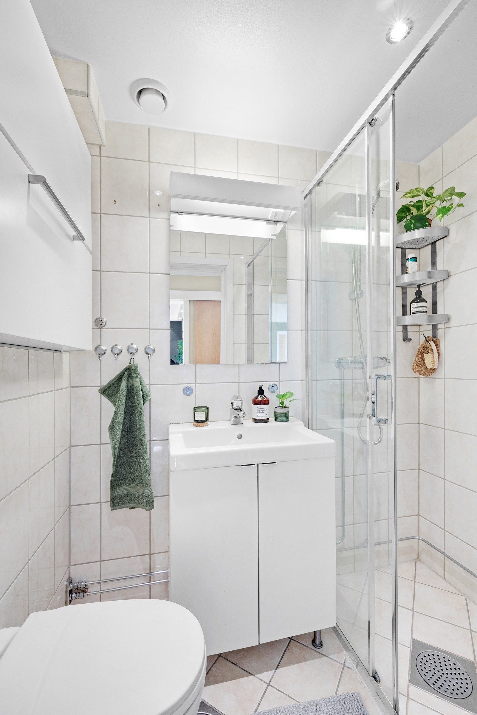 Badet har vegghengt toalett og servant med servantskap Galleribilde