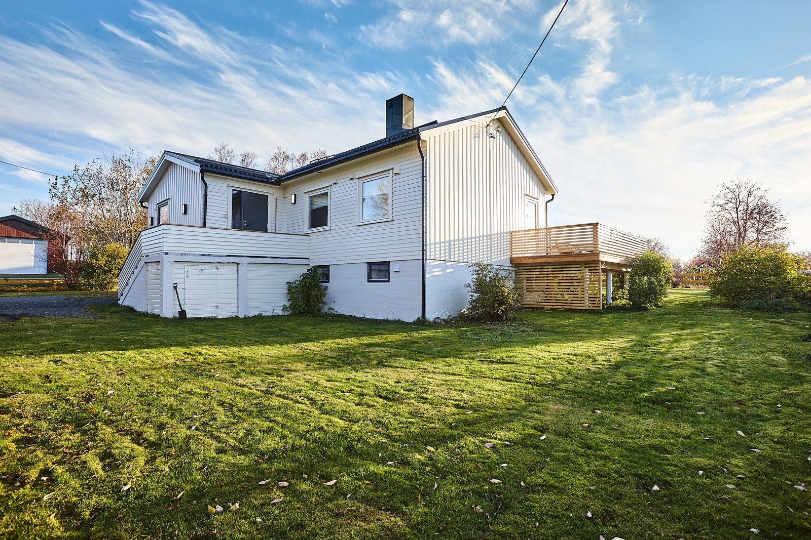 Opparbeidet uteområde med plen og beplantning. Diverse bærbusker er det også. Galleribilde