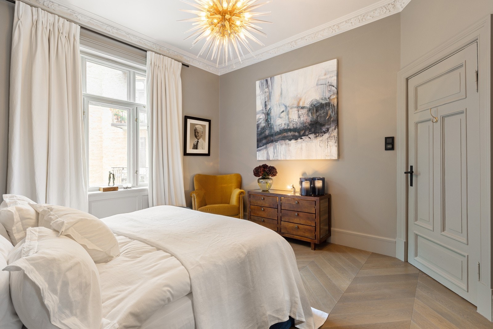 Hovedsoverommet har mørkere eikegulv med varme, lekker stukkatur og rosett i tak, spesiallaget garderobeskap med speilfronter og gråmalte rammer. Galleribilde