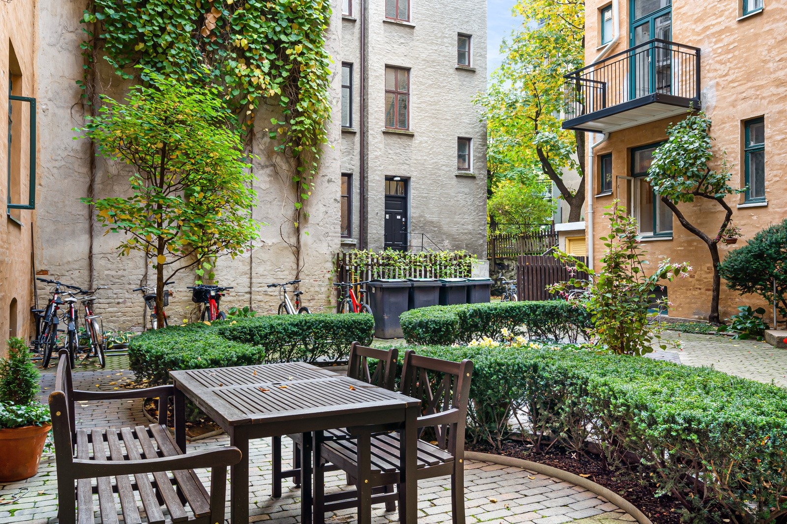 Gårdsrommet er pent opparbeidet med belegningsstein og trimmede busker som avgrenser soner for sittegrupper sommerstid. Galleribilde