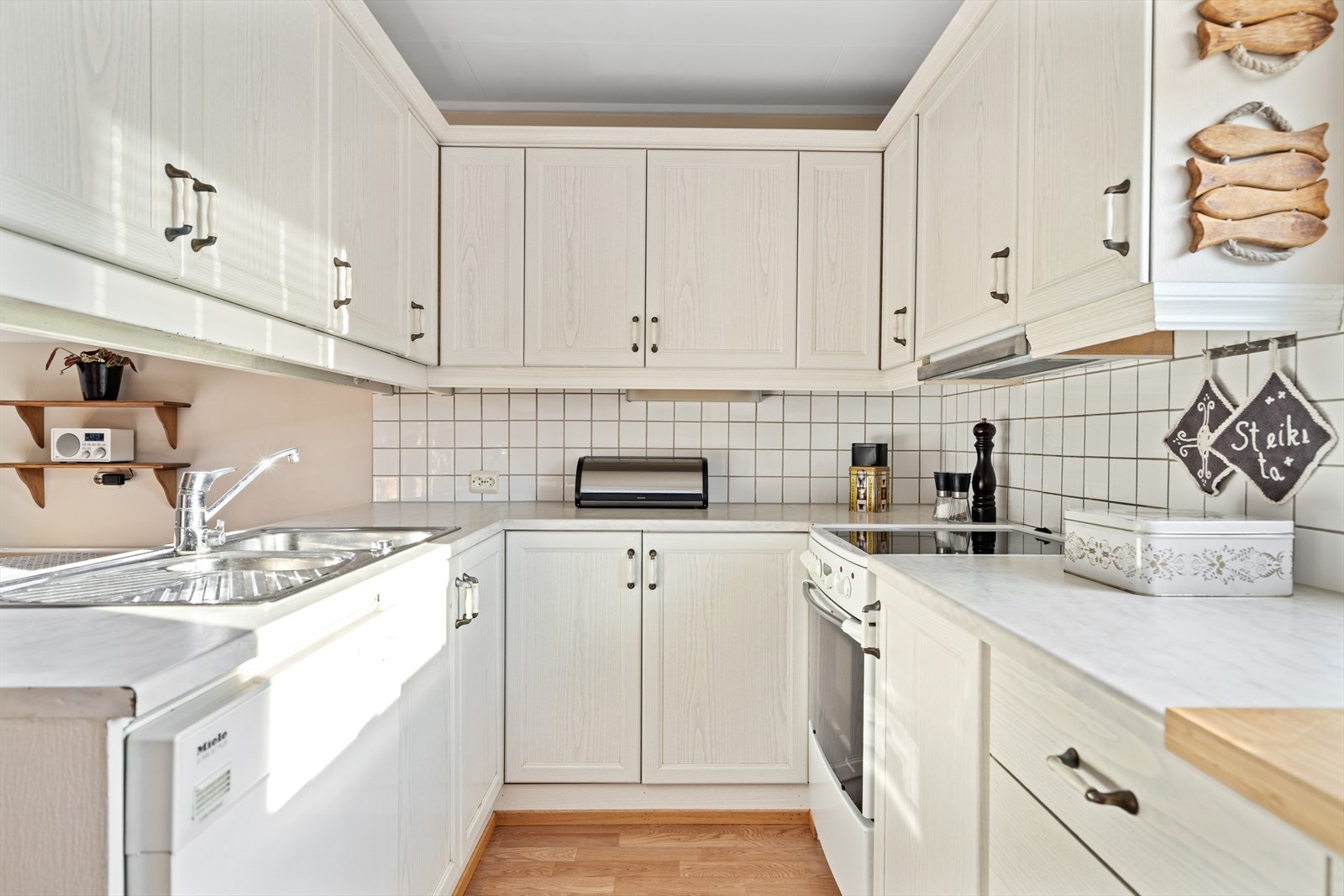 Innredningen er lys med profilerte fronter. Det er montert fliser over benken. Galleribilde