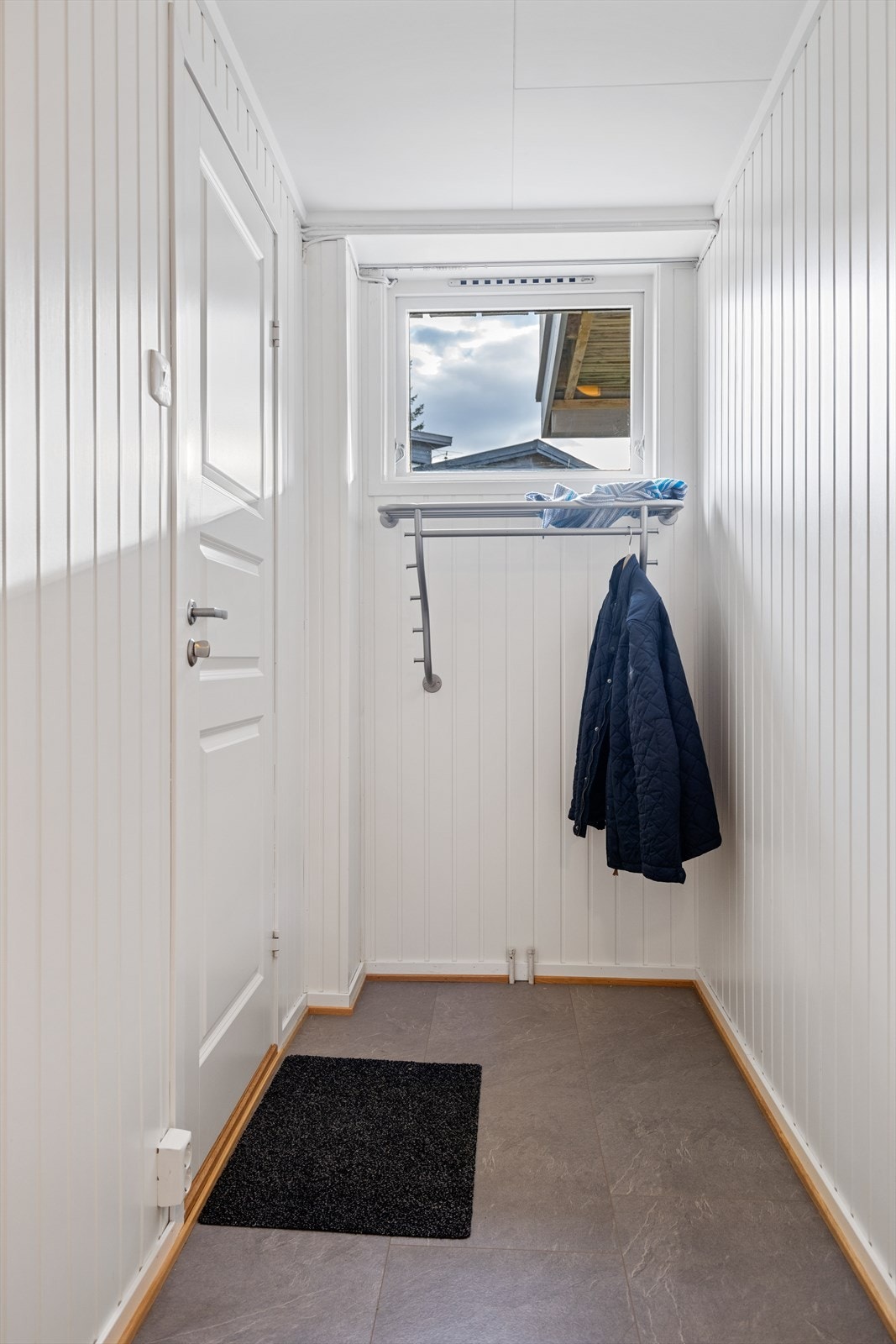 Entré til hybel med plass til yttertøy på en knaggerekke. Galleribilde
