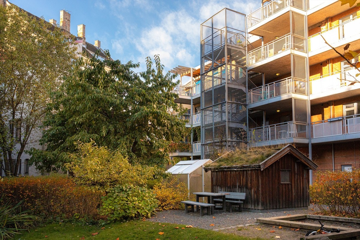 På tomten er det en grønn oase som består av et flott og frodig gårdsrom med trær, beplantning og lekeapparater. Galleribilde