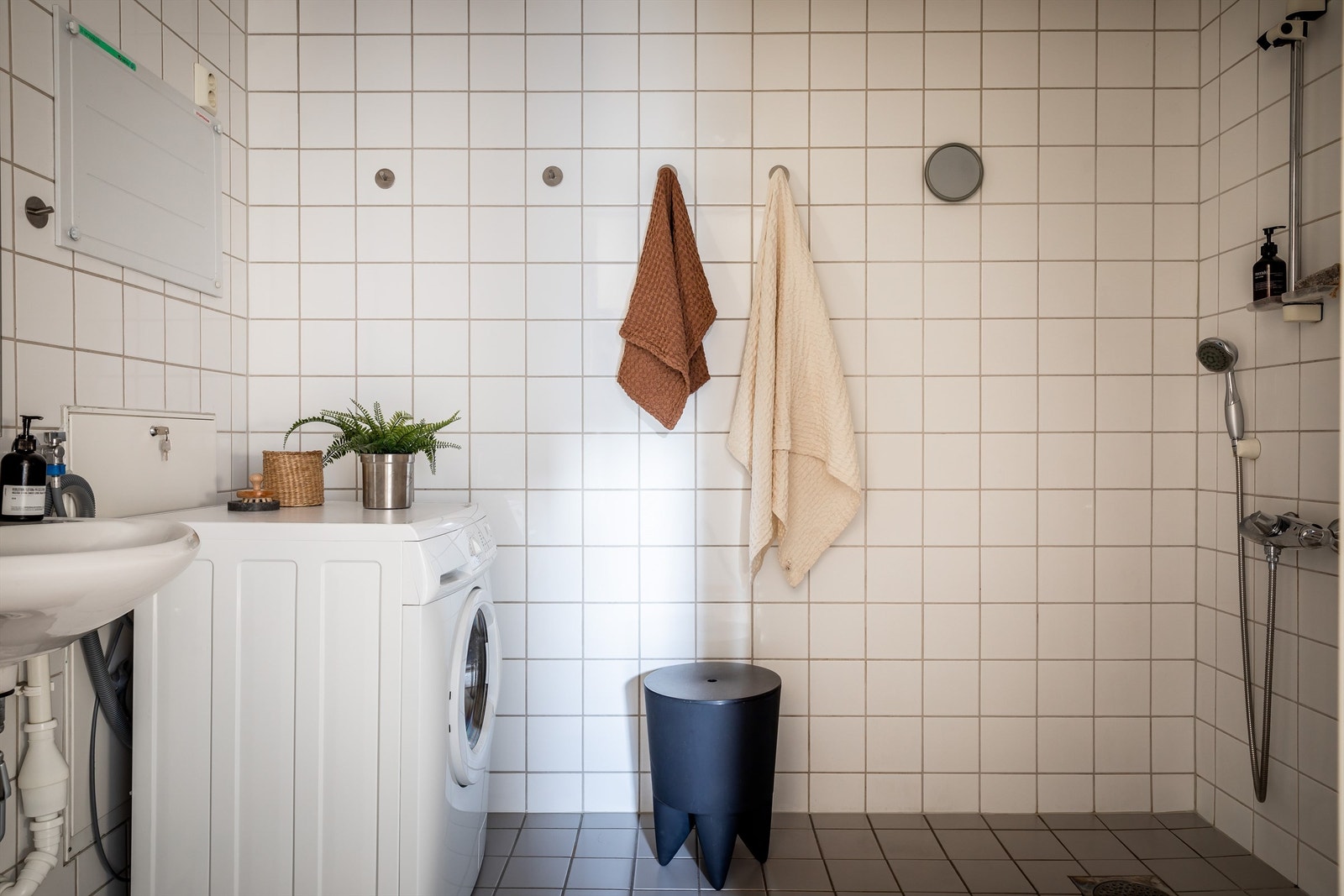 Bad/vaskerom i fra byggeår med vannbåren gulvvarme, fliser og med gulvstående toalett, servant med veggfester, dusjhjørne med blandebatteri og dusjutstyr. Galleribilde