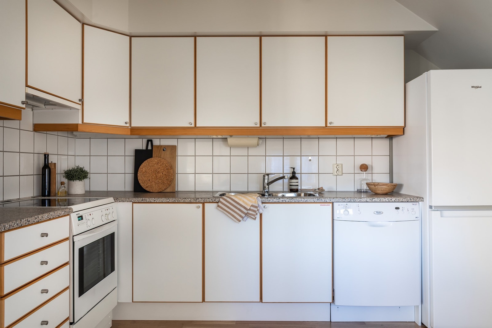 Det er en delvis åpen kjøkkenløsning, hvor kjøkkenet er fra byggeår og har en funksjonell skapinnredning med gode oppbevaringsmuligheter. Galleribilde