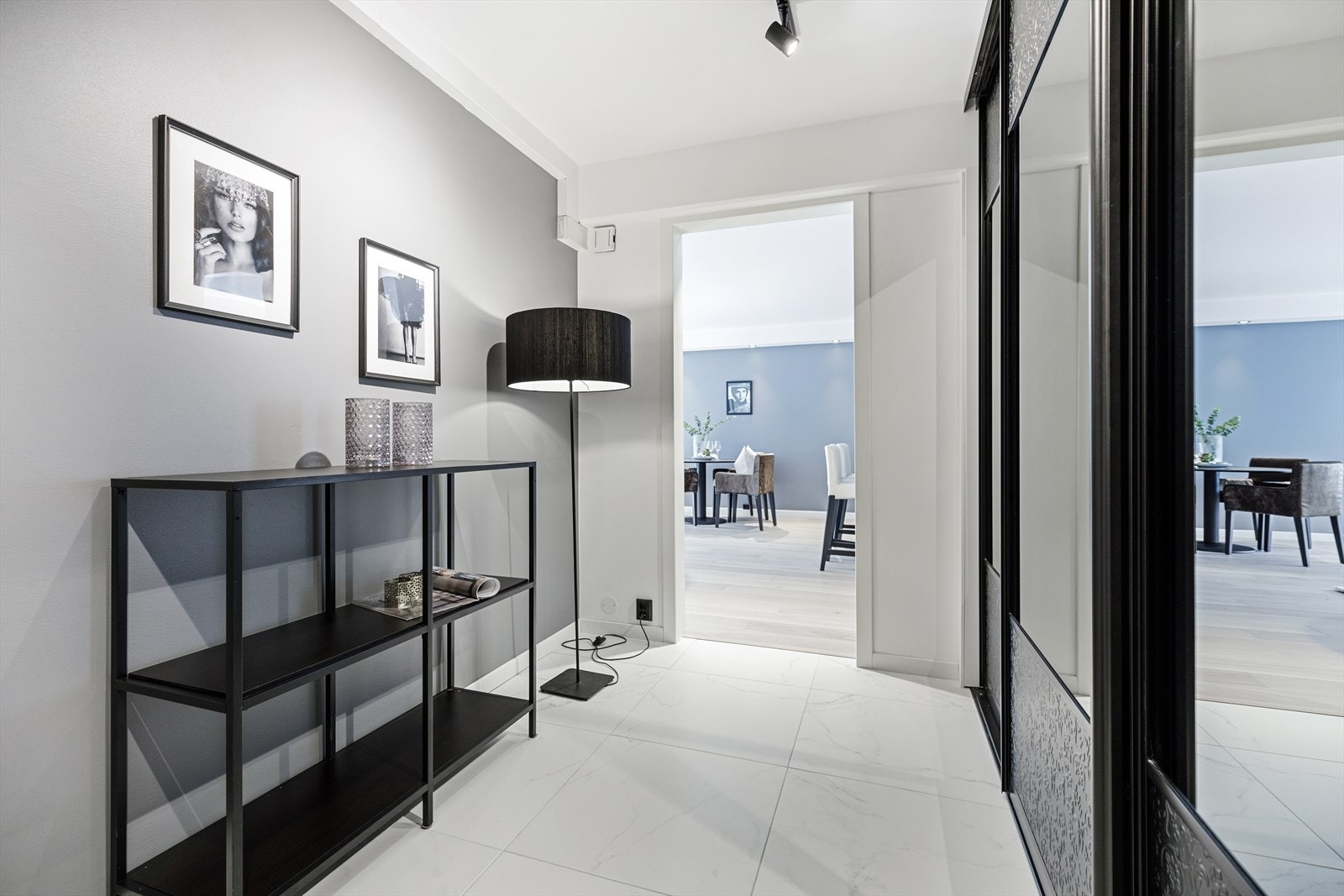 Innbydende entré med stor skyvedørsgarderobe, fliser på gulv og spotter i himling. Galleribilde