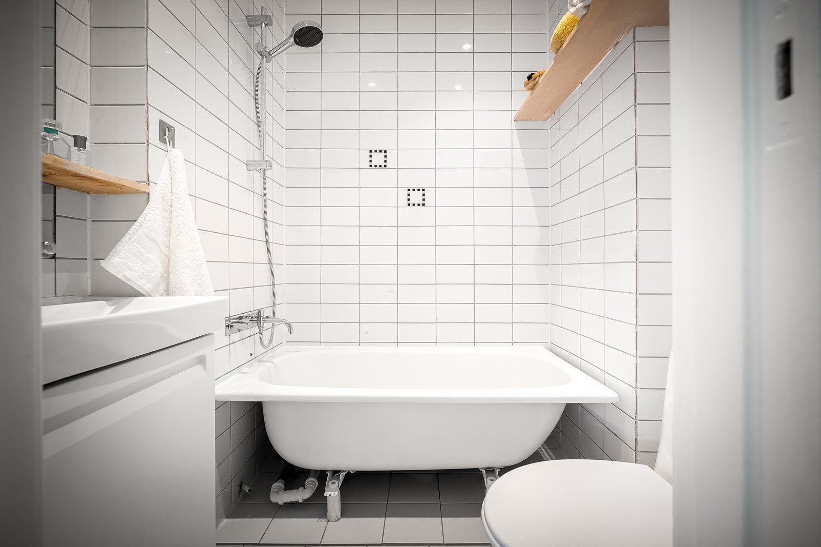 Badet er antatt å være fra ca. år 2000 og har hvite fliser på vegger og gulv Galleribilde