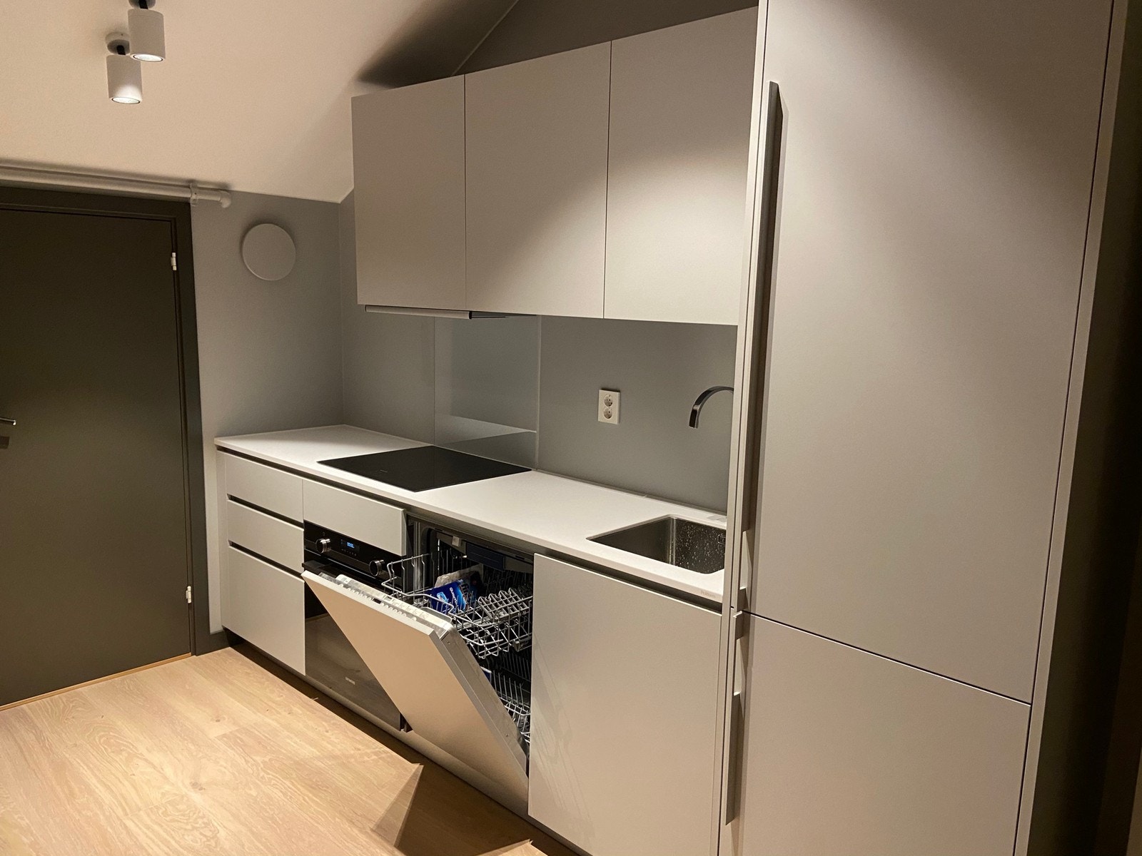 Kjøkken med oppvask, kjøleskap og komfyr, inngang bod i leiligheten Galleribilde