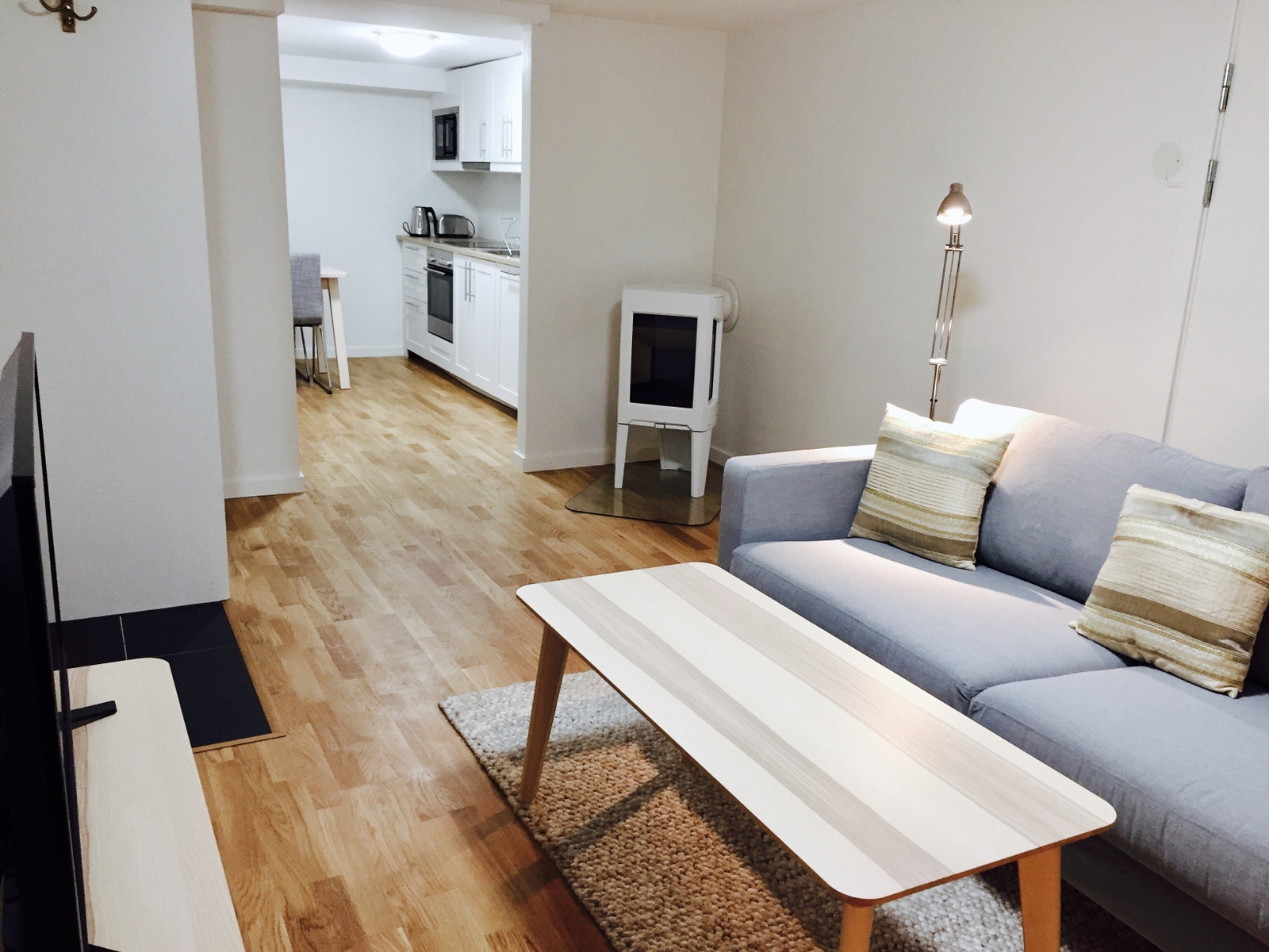 Lys og innbydende stue med peis, møblert med sofa, bord og TV. Galleribilde