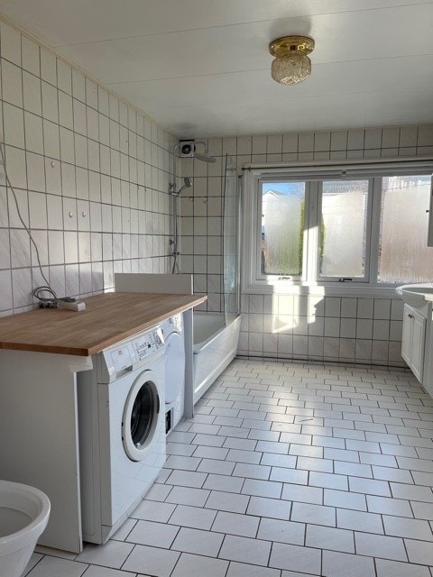 stort bad med toalett og hvitevarer Galleribilde