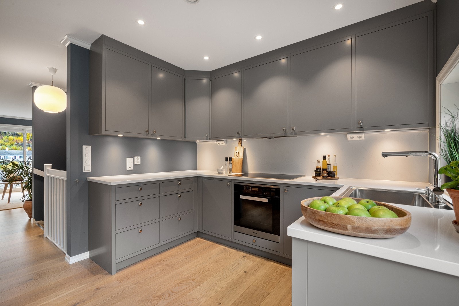 Kjøkkeninnredningen har glatte grå fronter og silestone benkeplate Galleribilde