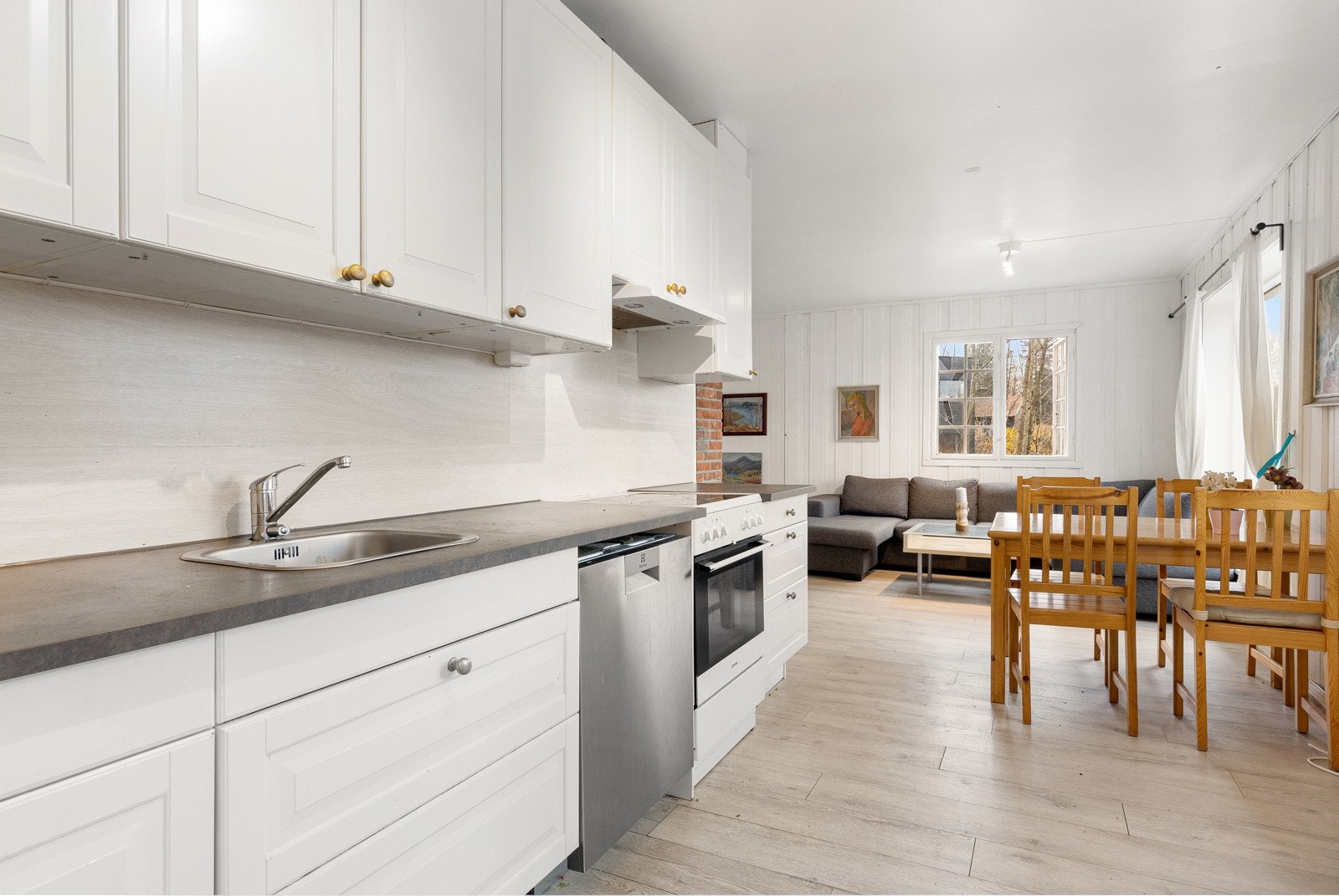 Kjøkkeninnredning med profilerte fronter og benkeplate av laminalt med nedfelt kum i stål. Galleribilde