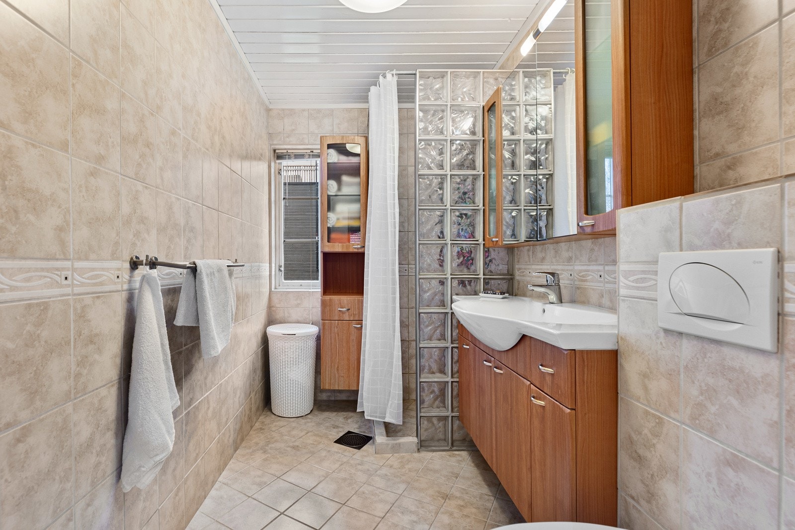 Badet i 1. etasje er fra 2008 og har sandfargede vegg- og gulvfliser, gulvvarme og vegghengt toalett. Galleribilde