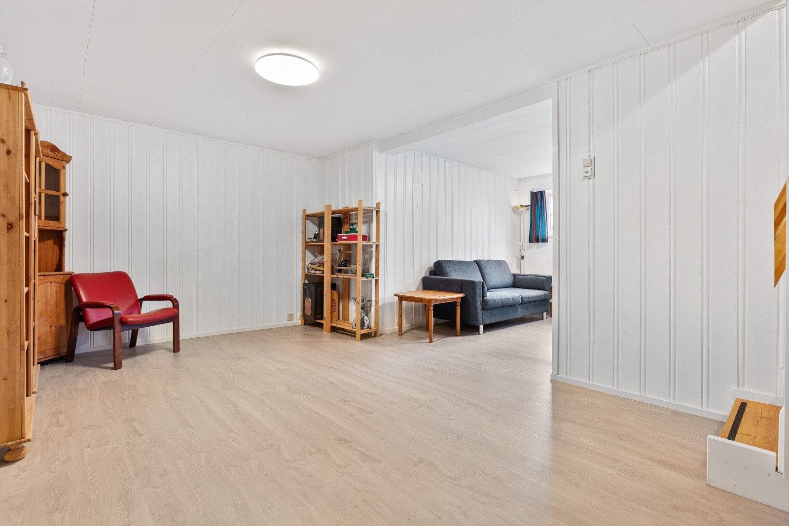 Stuen har hvitmalt panel på veggene og lyst laminatgulv med gulvvarme. Galleribilde