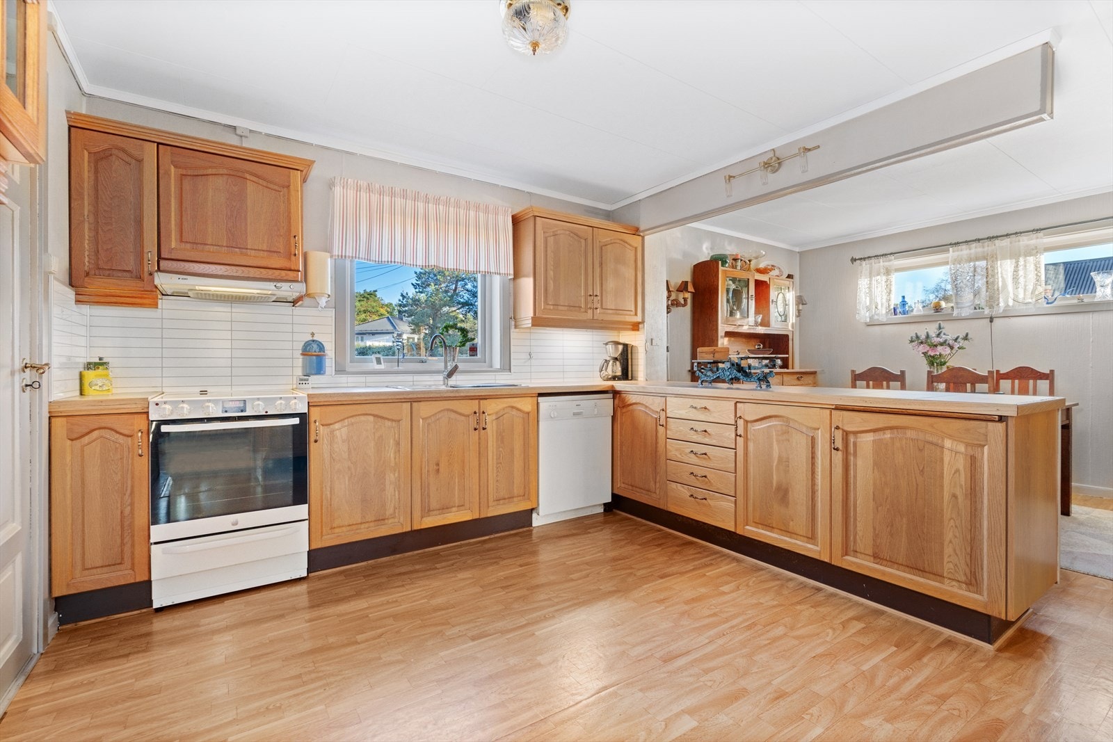 Delvis åpen kjøkkenløsning med mye skuffer og skap samt gode arbeidsflater. Galleribilde