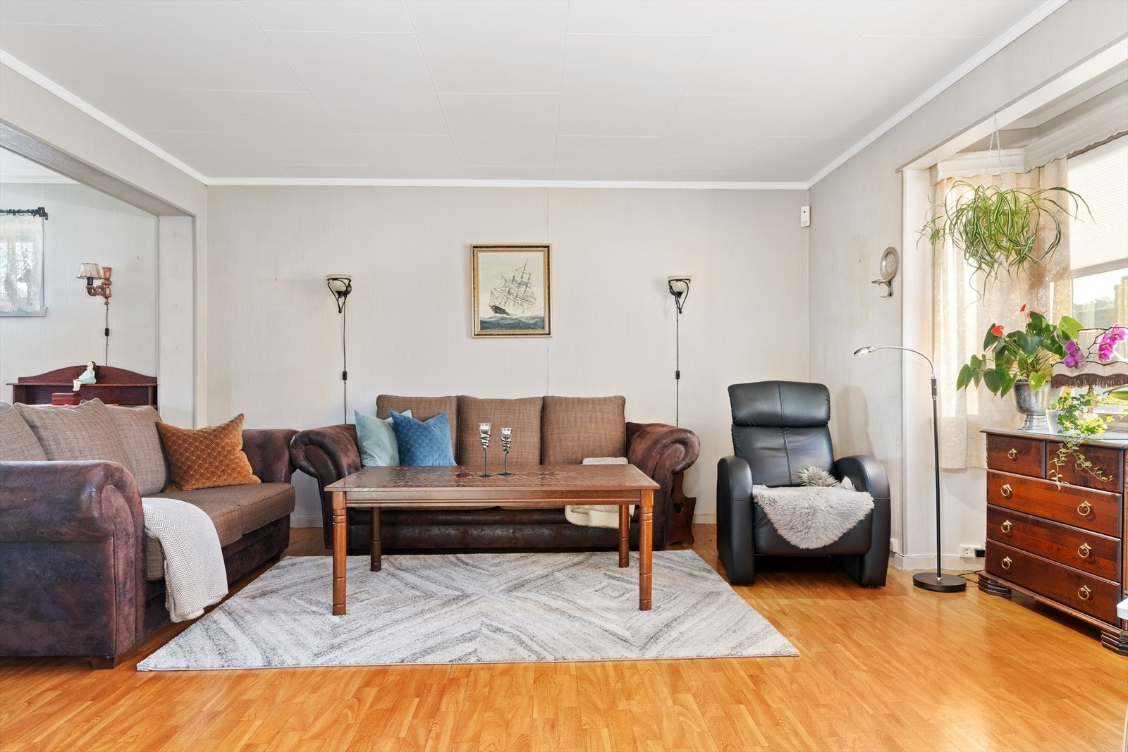 Lys og romslig stue som naturlig deles inn i tre soner. Galleribilde