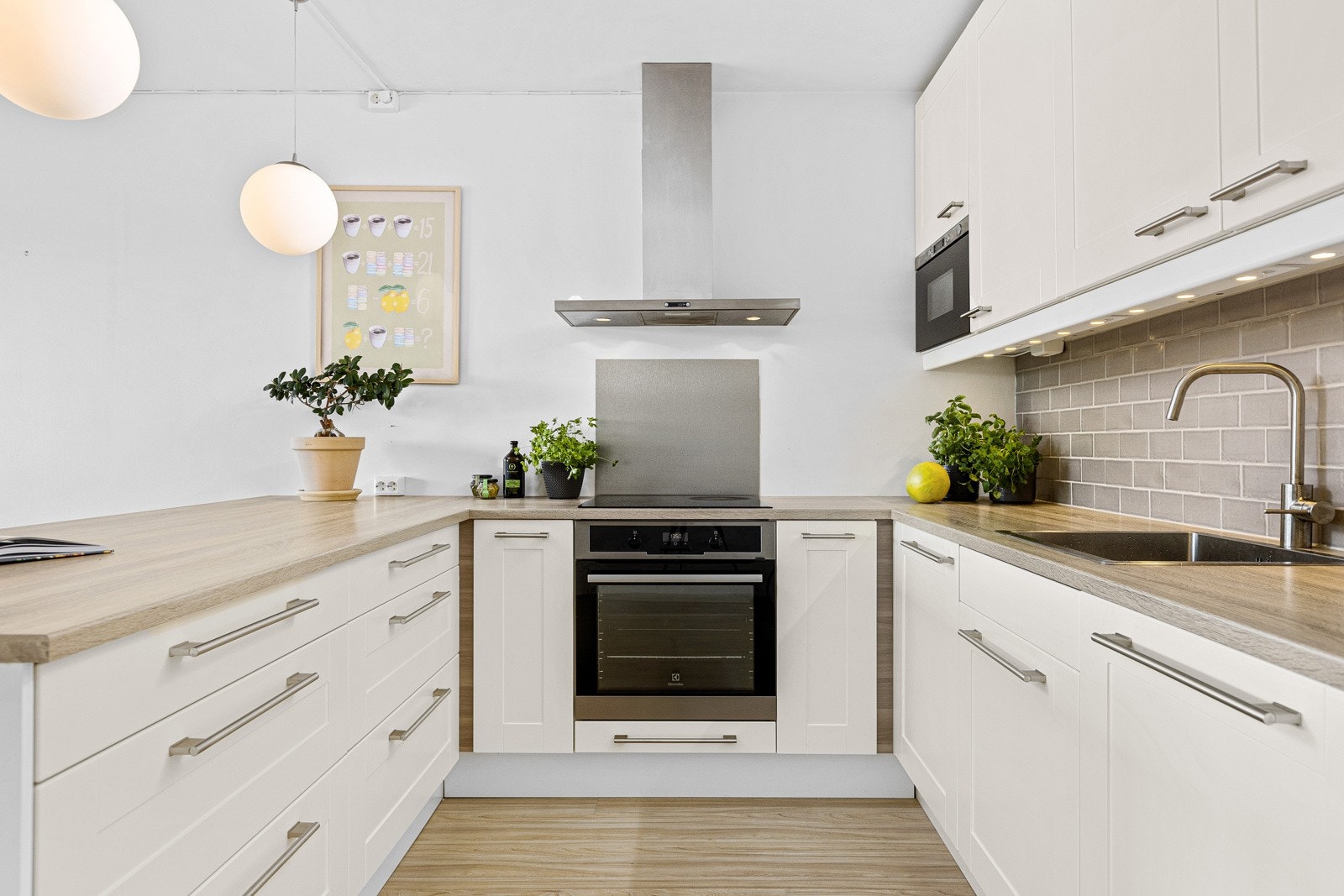 Lekker, kjøkkeninnredning fra IKEA med integrerte hvitevarer som Integrert induksjonsplatetopp, stekeovn, mikrobølgeovn, oppvaskmaskin og kjøle-/fryseskap. Galleribilde