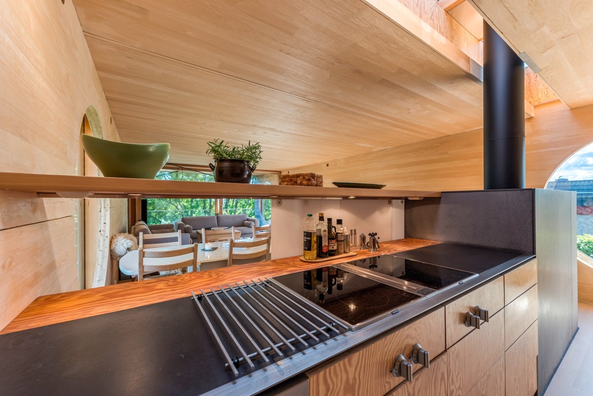 Kjøkkenet har innredning med fronter i glatt furufiner og integrerte kvalitetshvitevarer Galleribilde