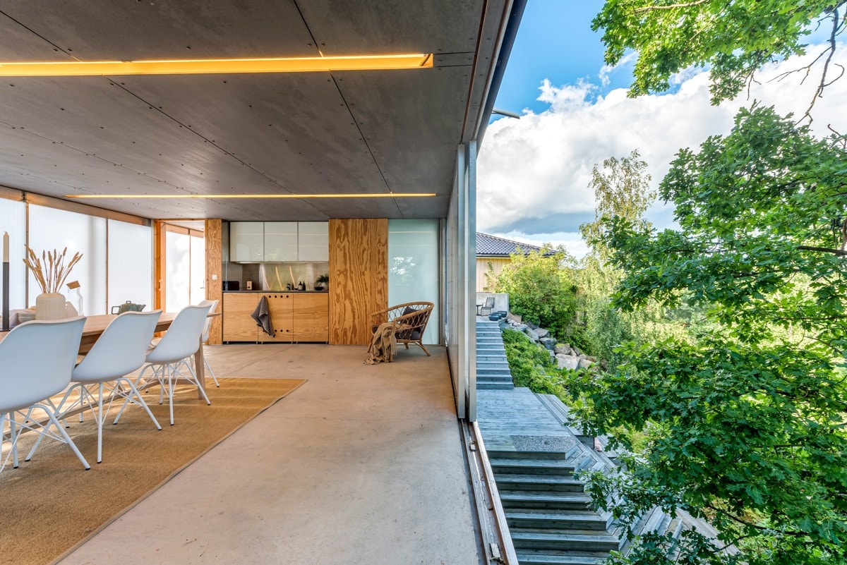 Fra gårdsplassen er det lagt tretrapper i terrenget til nedsiden av huset. Galleribilde