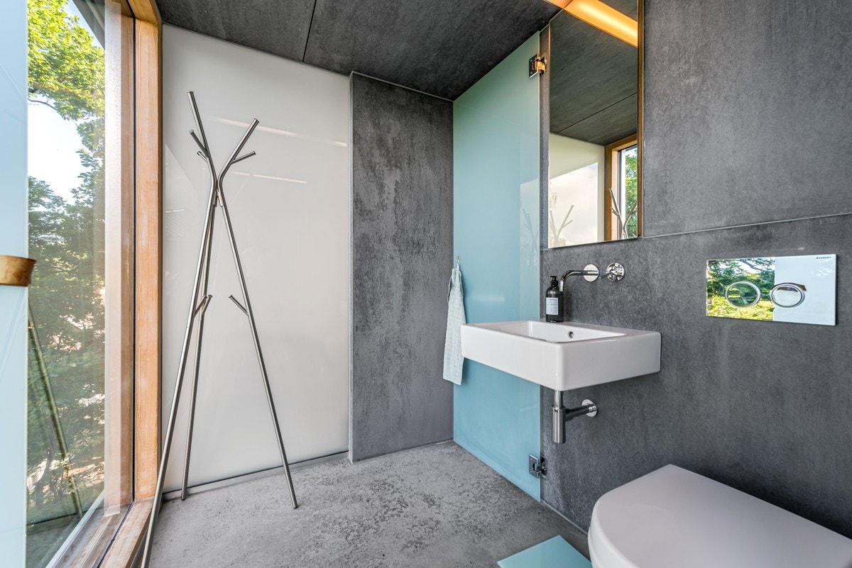 Dette badet ligger i første etasje, i tilknytning til entreen. Badet har svingbar dusjvegg i frostet glass og en spektakulær vindusflate mot skog og natur. Galleribilde