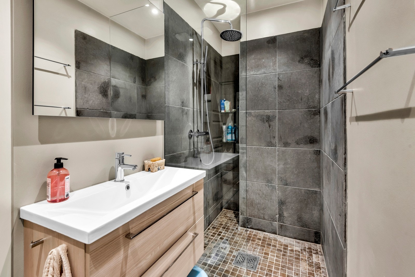 Bad I - Delikat baderom innredet med servantløsning med underskap, dusj, samt toalett Galleribilde