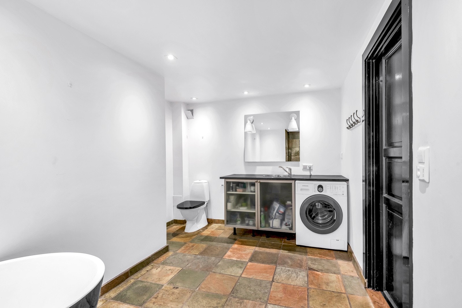 Badet er innredet med servantløsning, badekar, dusj og toalett Galleribilde