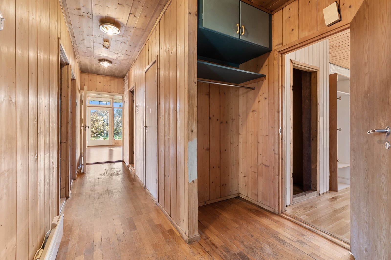 Gang med parkettgulv og veggoverflater av panel. Galleribilde