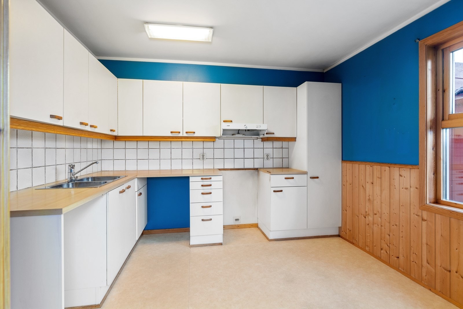 Kjøkkenet ligger i eget rom og består av over- og benkeskap i vinkelform. Galleribilde