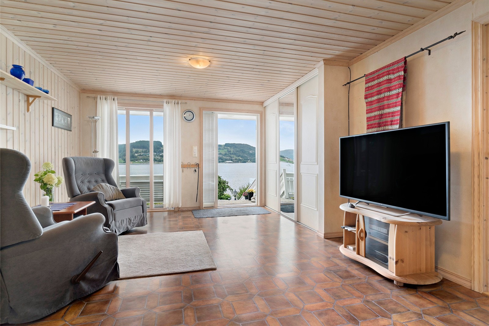 Stor og åpen entre/hall som idag brukes til en kjekk tv-stue. Flott sjøutsikt også her fra underetajsen. Galleribilde