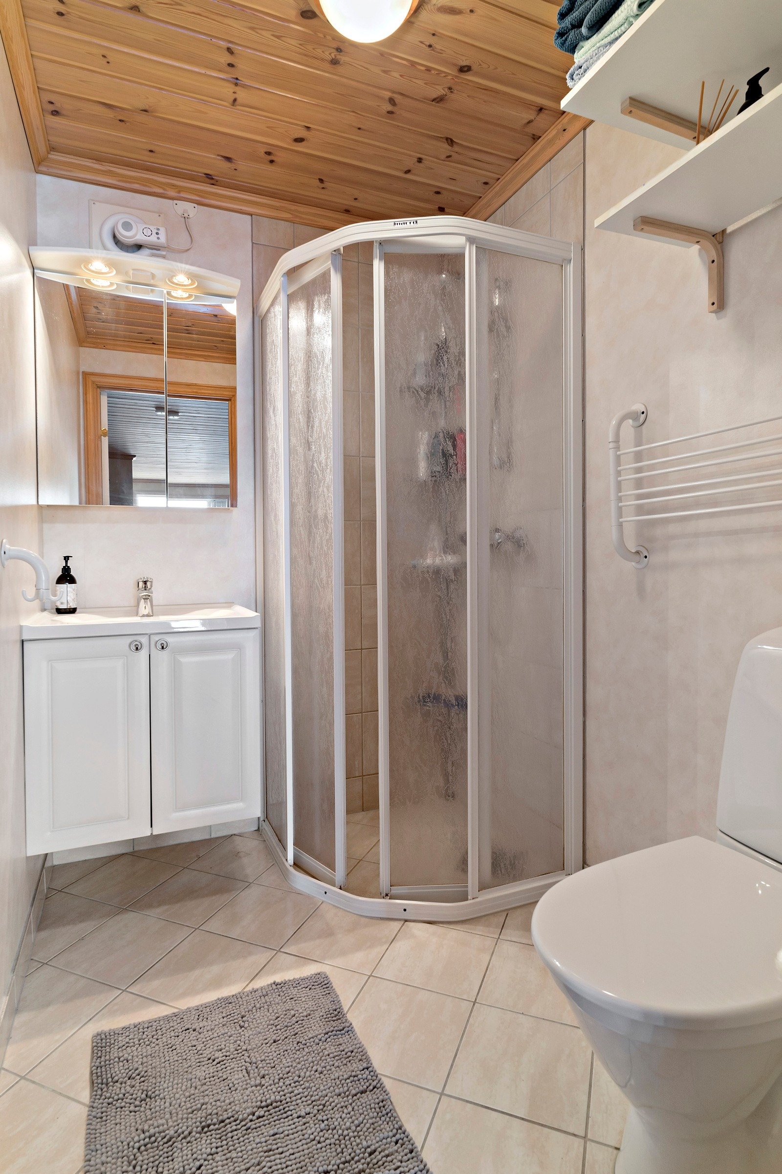 Bad i underetasje utstyrt med fliser på gulv og vinyltapet på vegg. Galleribilde