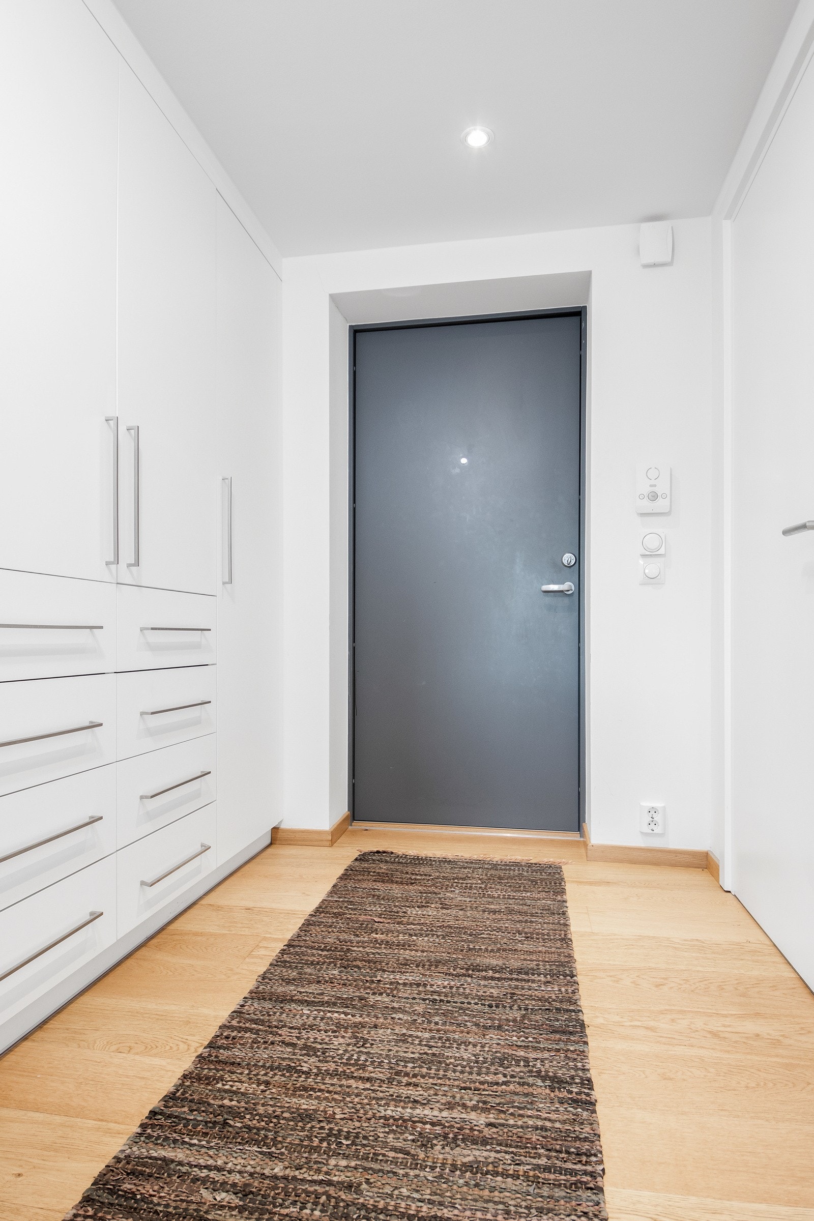 Entreen har hvitmalte vegger med listefritt til tak, enstavs parkettgulv og vannbåren gulvvarme - en standard som går igjen i alle oppholdsrom. Galleribilde