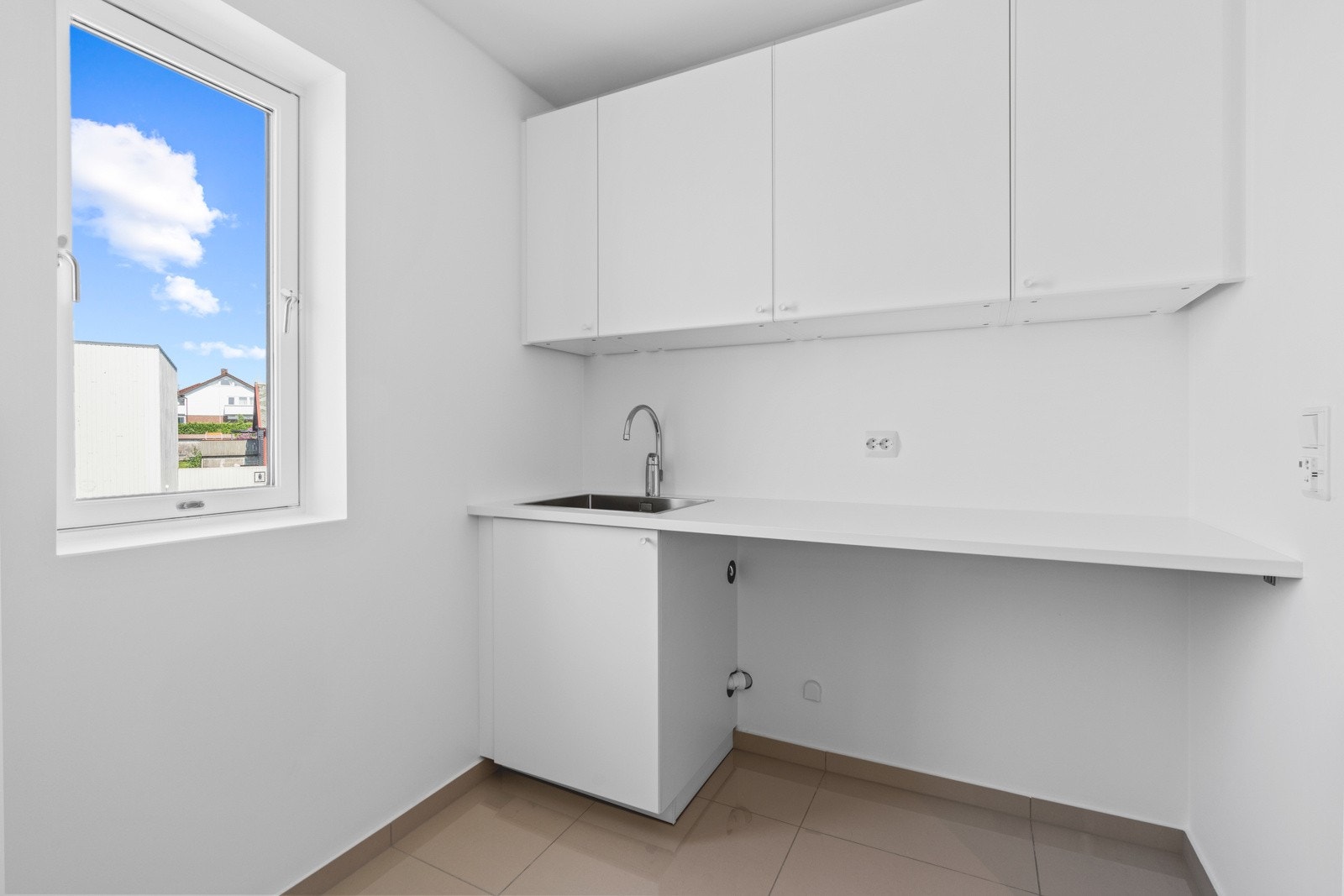 Vaskerommet har flislagt gulv og en praktisk innredning med nisje for vaskemaskin. Galleribilde