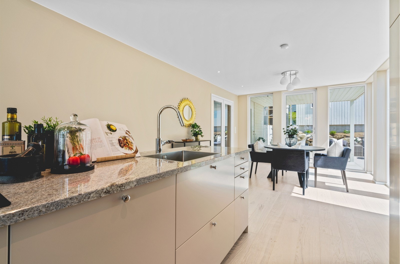 Med kjøkken i midten får man naturlige soner for sofa og spisestue. Galleribilde