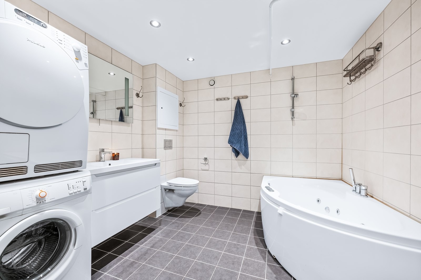 Boligen har et delikat baderom som ble modernisert i regi av borettslaget i 2018. Badet er innredet med lyse fliser på vegger og grå fliser over varmekabler på gulv. Galleribilde