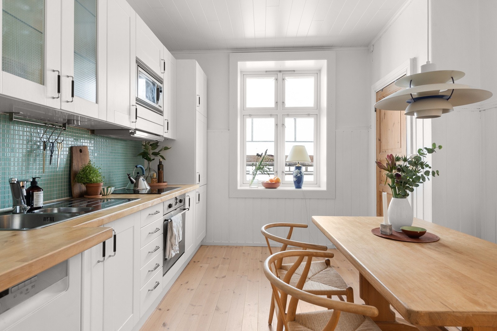 Leiligheten har et stort og lyst separat kjøkken som vender ut mot den idylliske bakgården. Kjøkkenet har lyse fine tregulv og lysmalte overflater malt i 2021. Galleribilde