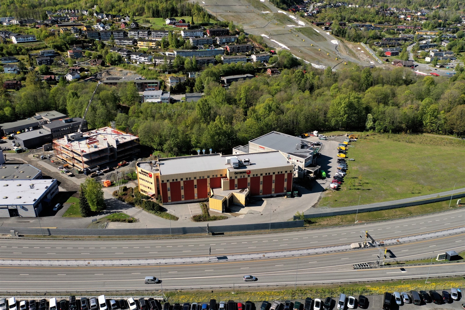 Eiendommen ligger inntil E16 Oslo-Bergen, hele 5.etg. er ledig, samt et mindre areal i 3.etg. (eldre dronefoto) Galleribilde