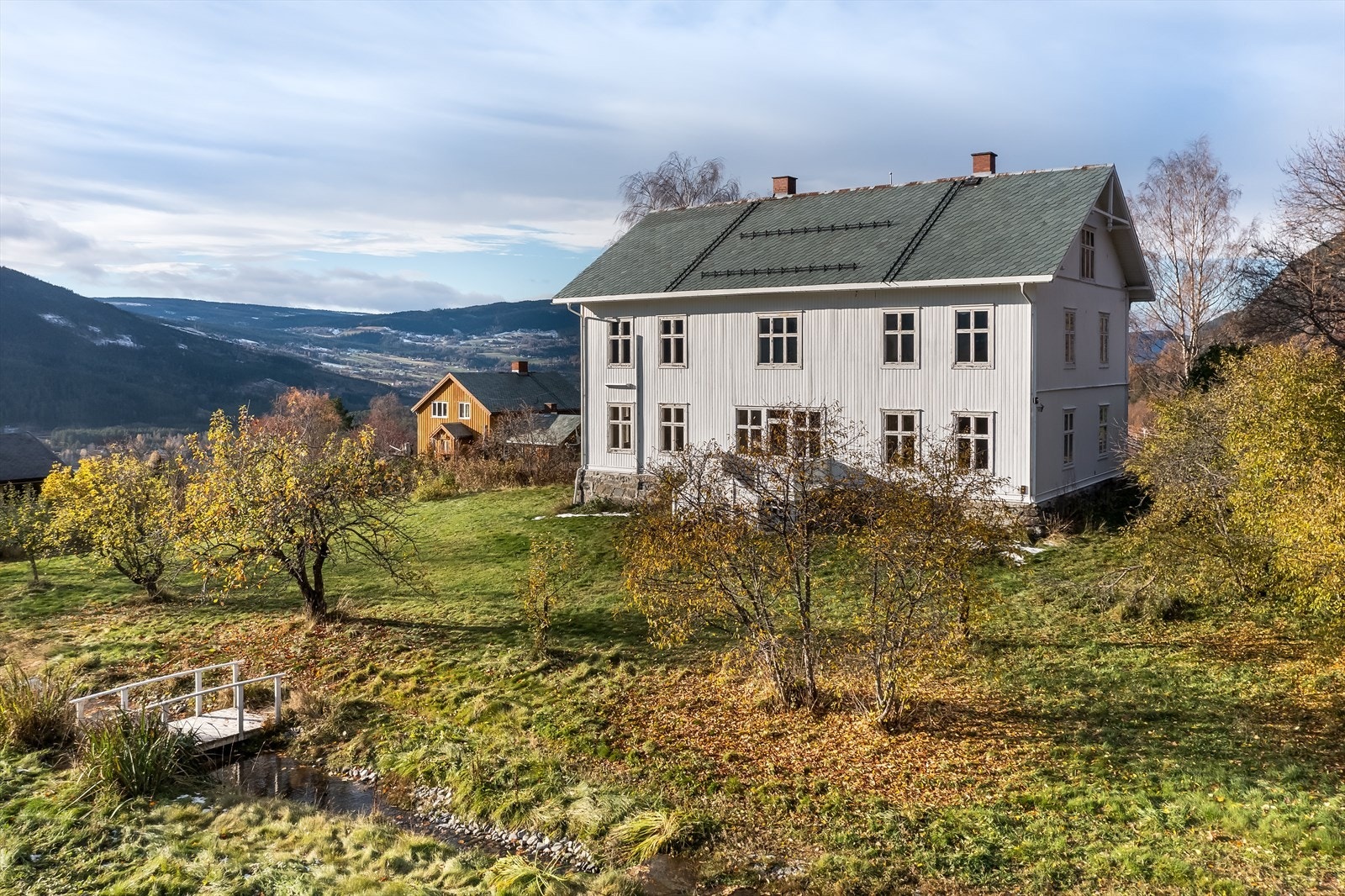 Stor opparbeidet tomt på 3,7 mål med blant annet bærbusker, bekk, hagebro og paviljong. Galleribilde