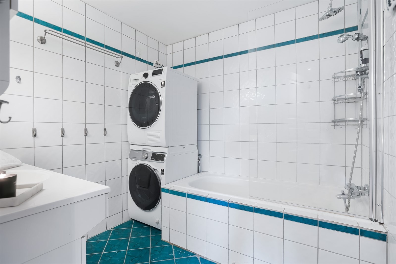 Fliser på gulv og vegg. Avsatt plass vaskemaskin og tørketrommel. Badekar, vegghengt servantskap. Galleribilde