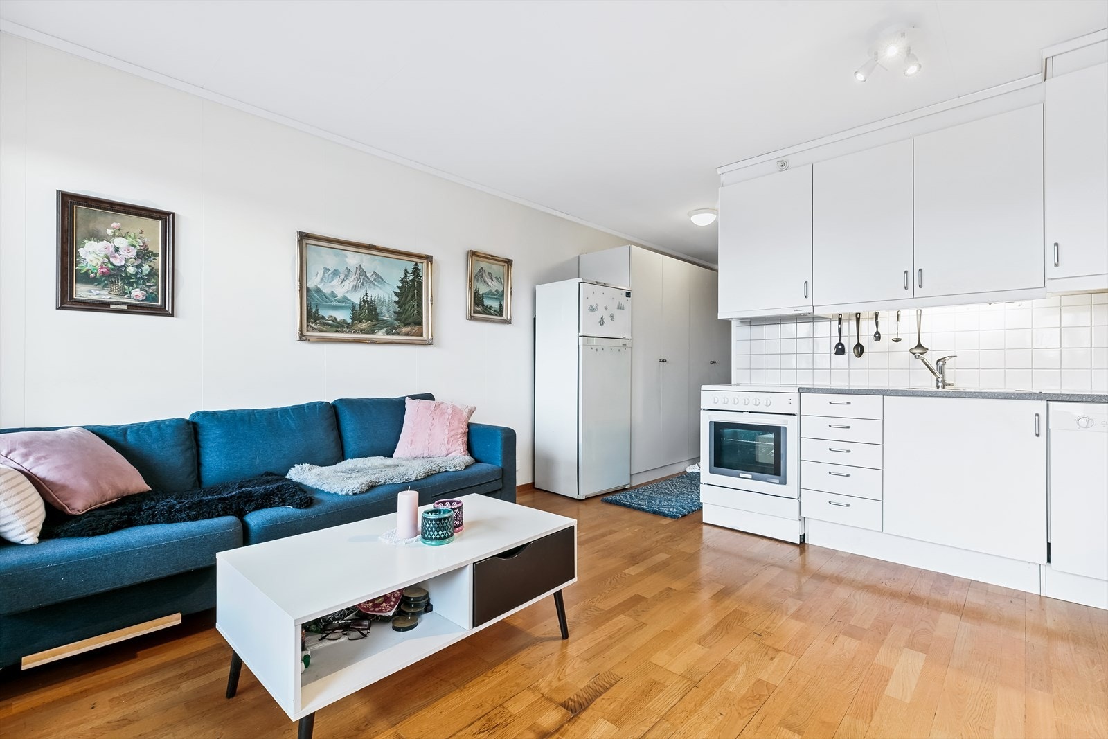 Den åpne kjøkkenløsningen har takhøy kjøkkeninnredning med lyse, glatte folierte fronter. Galleribilde