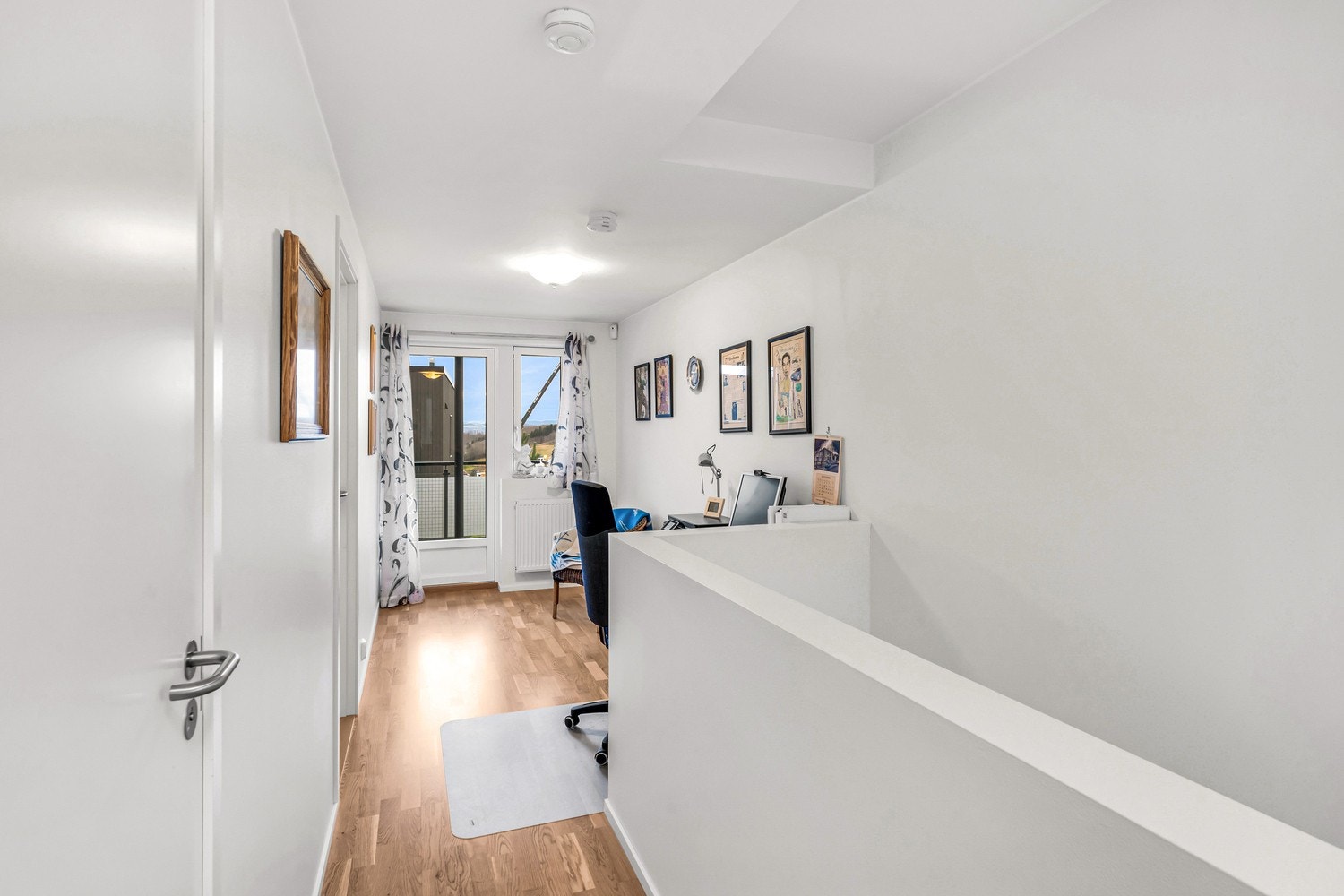 Praktisk kontorhjørne og utgang til en solrik balkong. Galleribilde