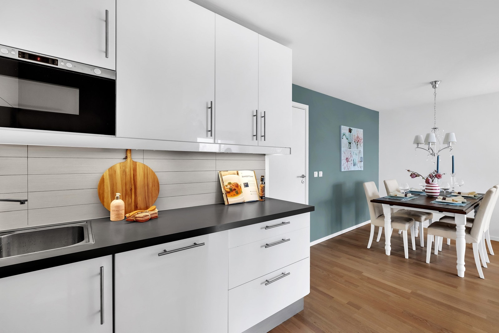 Fliser over kjøkkenbenk. Benkeskapsbelysning og stikkontakter over kjøkkenbenk. Galleribilde