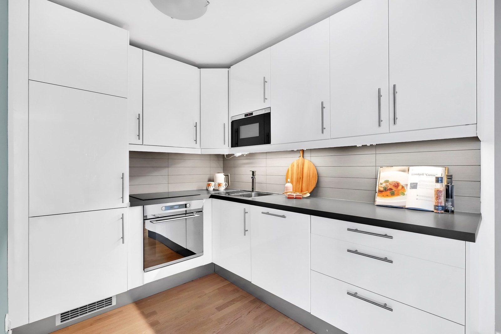 Integrerte hvitevarer fra IKEA. Nedfelt induksjonsstopp, stekeovn og oppvaskmaskin. Mikrobølgeovn i overskap. Kjøleskap med frysedel fra beko. Galleribilde