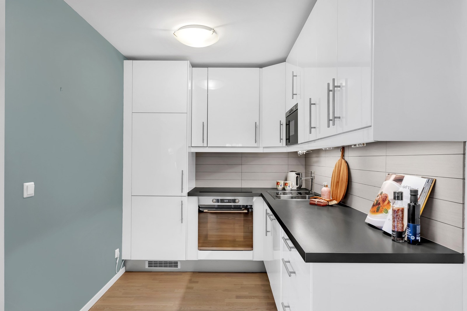 IKEA kjøkkeninnredning med hvite slette fronter. Benkeplater av laminat. Galleribilde