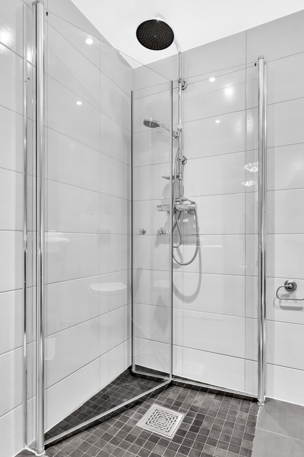 Dusjsone med innfellbare dører av glass. Dusjarmatur tilkoblet veggmontert regndusj og hånddusj. Galleribilde