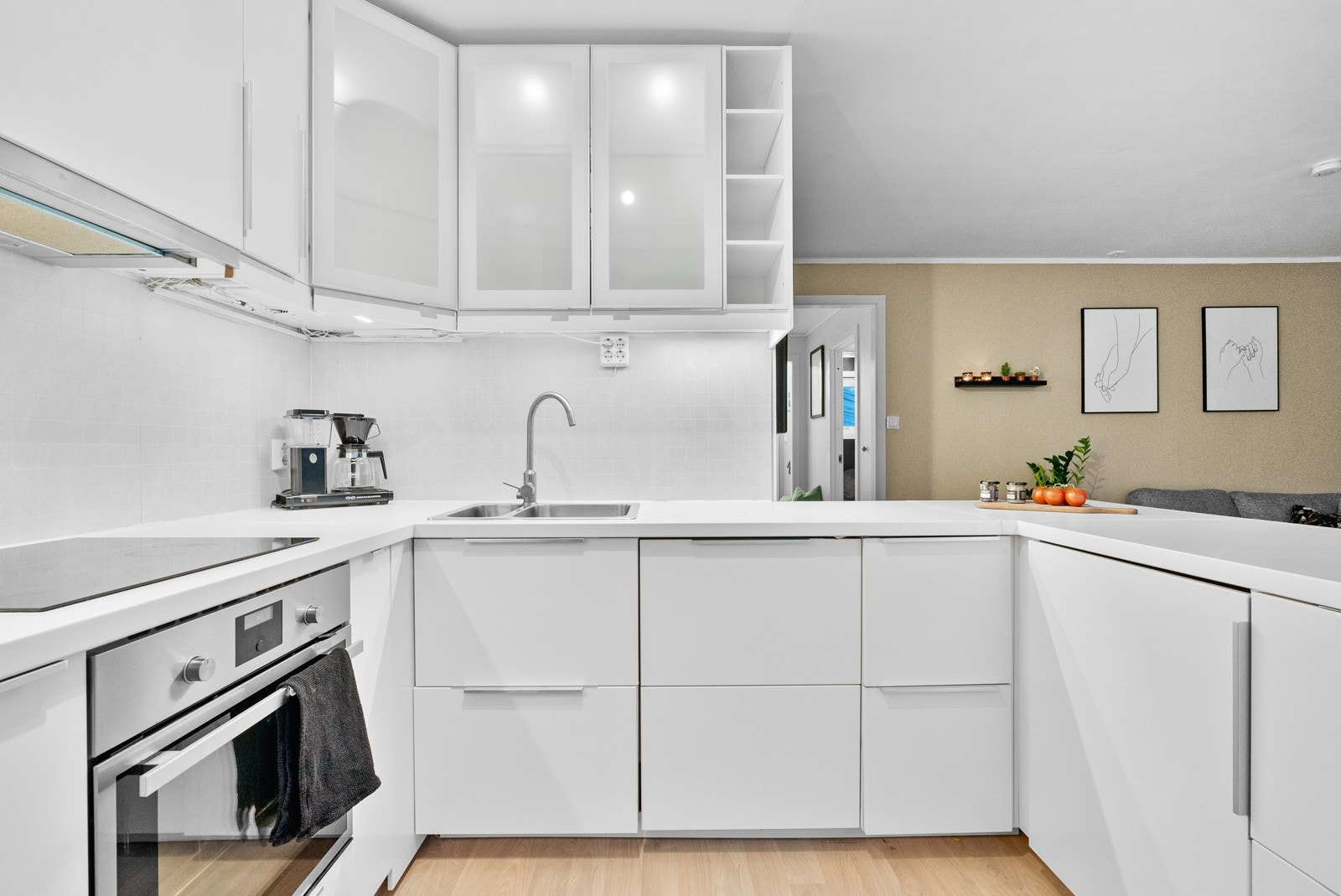 Lysmalt kjøkkeninnredning med integrerte hvitevarer Galleribilde