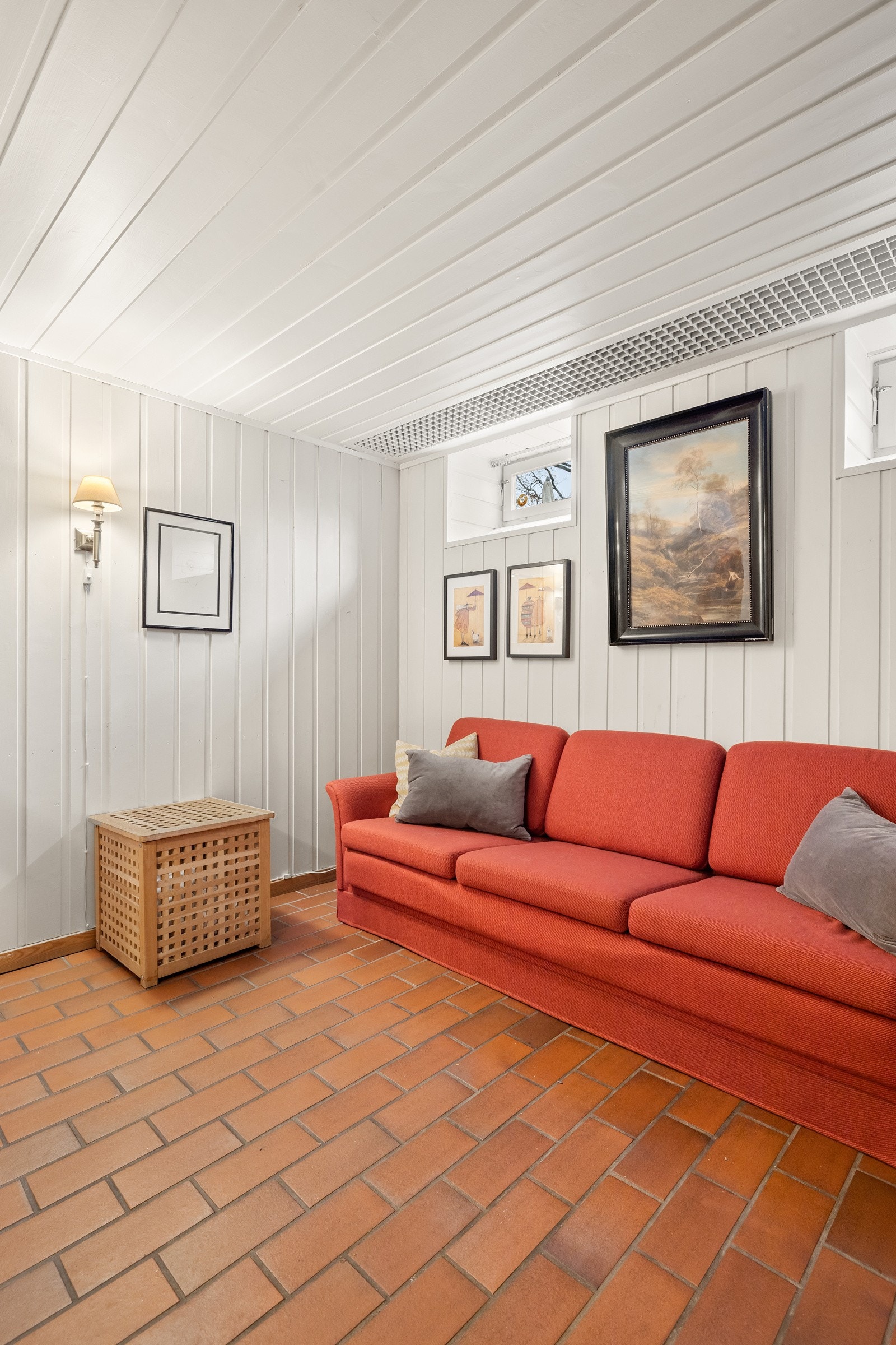 Kjellerstuen er innredet med sofagruppe og ulike oppbevaringsløsninger. Galleribilde