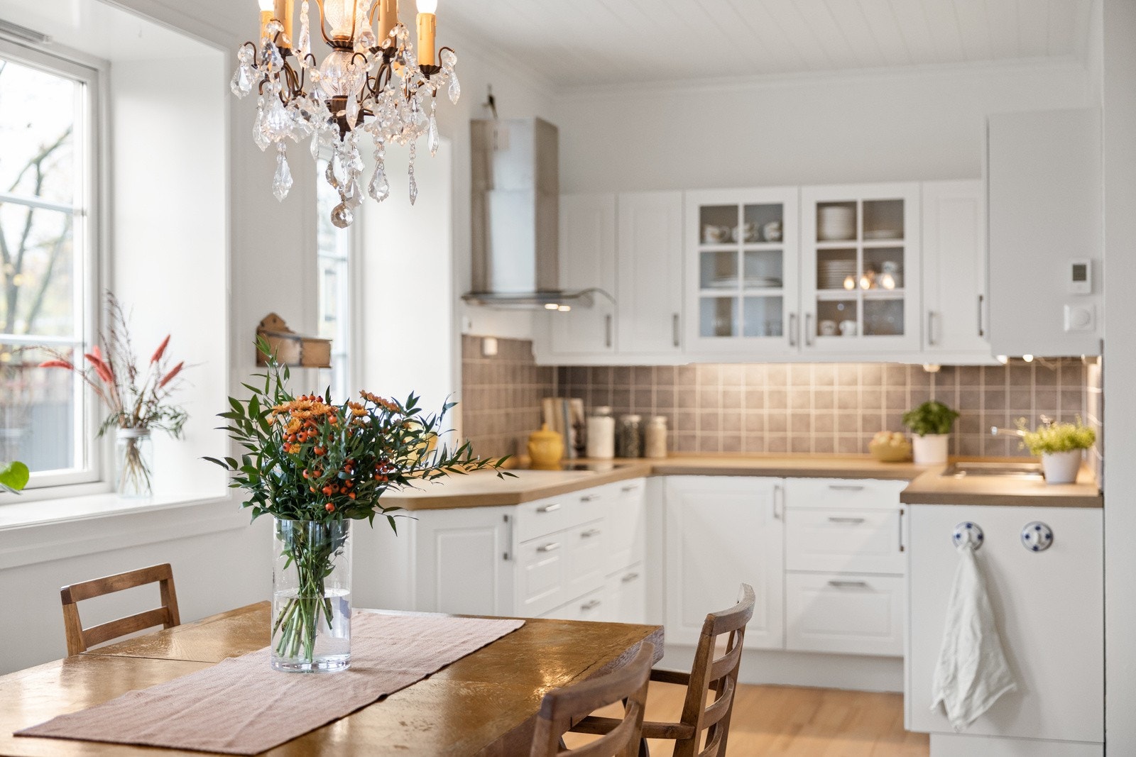 Kjøkkeninnredning er fra ca. 2020, med hvite/profilerte fronter. 2 fronter med glassfelt. Det er lys under overskap, laminat benkeplater og nedfelt oppvaskkum. Galleribilde